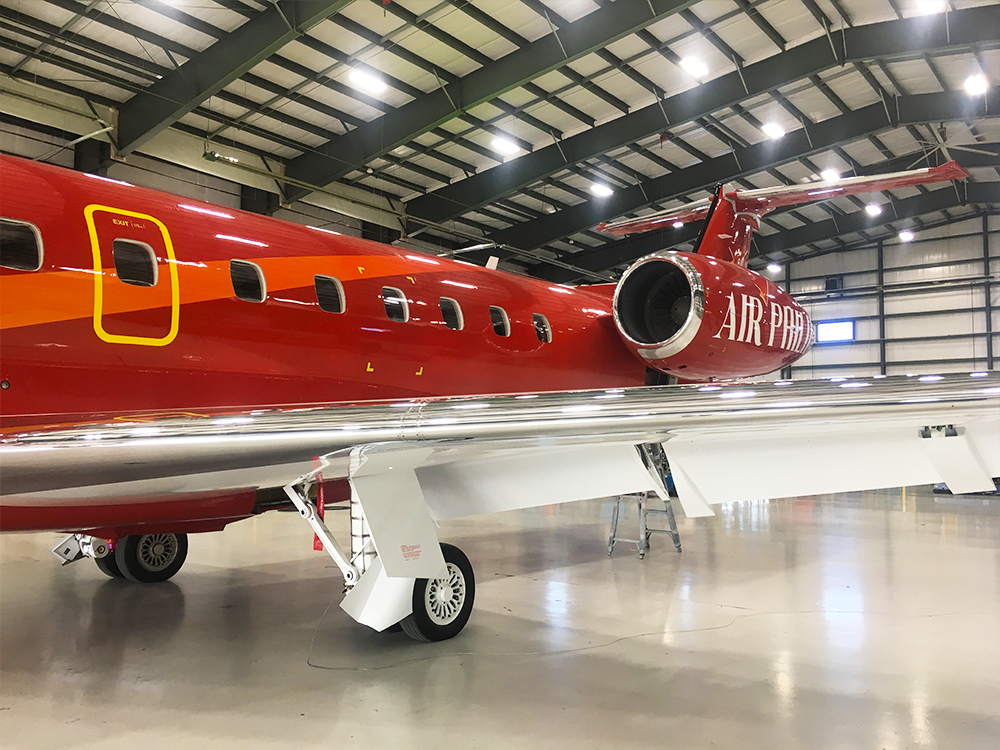 close up of red embraer erj145 exterior paint inside hangar