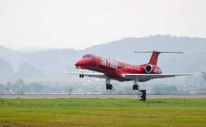 newly painted red embraer erj145 landing on airport runway