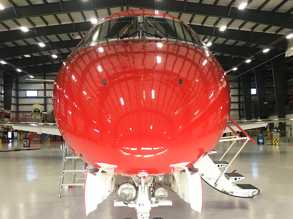 nose of red embraer erj145 inside new united goderich hangar