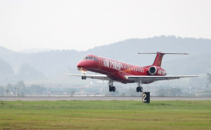 red embraer erj commercial airline landing on runway